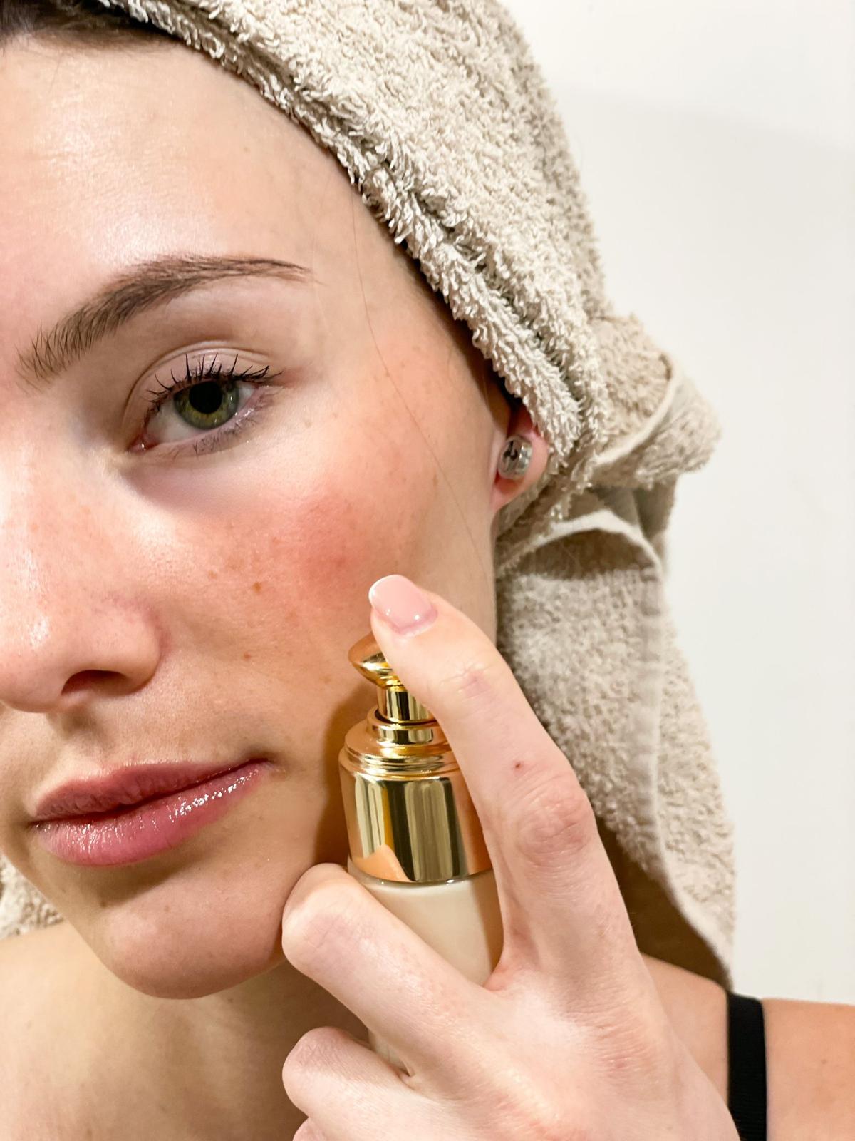 Femme appliquant la crème illuminatrice Divine de Nicoleta Cosmetics, enrichie en or 24k et squalane végétal.